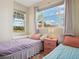 Comfortable bedroom with twin beds, side table and window with natural light at 2345 Felicity Pl, North Port, FL 34289