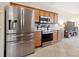 Modern kitchen with stainless steel appliances, tile flooring, and natural wood cabinets at 2345 Felicity Pl, North Port, FL 34289