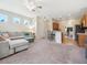 Spacious living room with access to the kitchen, comfortable sofa, and natural light at 2345 Felicity Pl, North Port, FL 34289