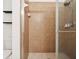 Walk-in shower featuring neutral tile, glass doors, adjustable shower head, and convenient shelving at 2345 Felicity Pl, North Port, FL 34289