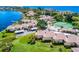 Aerial view of waterfront community showcasing lush landscaping, pool, tennis courts and boat docks at 4234 Gulf Of Mexico Dr # E2, Longboat Key, FL 34228