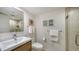 Bright bathroom features a sink, commode, shower and a vanity with storage at 4234 Gulf Of Mexico Dr # E2, Longboat Key, FL 34228