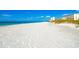 Expansive white sand beach with calm turquoise water and nearby beachfront buildings at 4234 Gulf Of Mexico Dr # E2, Longboat Key, FL 34228