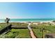 Beautifully landscaped beach access with a wooden walkway over dunes to the ocean at 4234 Gulf Of Mexico Dr # E2, Longboat Key, FL 34228