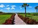 Scenic beach access with a brick path leading to the ocean through lush greenery at 4234 Gulf Of Mexico Dr # E2, Longboat Key, FL 34228