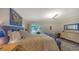 Bright bedroom with a blue-framed bed, neutral walls, and a sliding glass door leading to an outdoor space at 4234 Gulf Of Mexico Dr # E2, Longboat Key, FL 34228