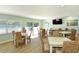 Light and bright community room with tables, chairs, large windows and a flat screen TV at 4234 Gulf Of Mexico Dr # E2, Longboat Key, FL 34228