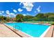 Community pool and sun deck with lounge chairs surrounded by lush landscaping near the tennis court at 4234 Gulf Of Mexico Dr # E2, Longboat Key, FL 34228