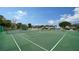 The community tennis court is surrounded by mature trees and lush landscaping, offering a great place to play at 4234 Gulf Of Mexico Dr # E2, Longboat Key, FL 34228