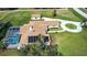 Aerial view of a brown roof, screened-in pool, circular driveway and solar panels at 5750 Saddle Oak Trl, Sarasota, FL 34241