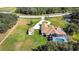 A drone's-eye view highlights the house, circular driveway, manicured lawn, pool and white fence at 5750 Saddle Oak Trl, Sarasota, FL 34241