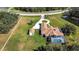 Aerial view shows the house's circular driveway, manicured lawn, pool, and white fence at 5750 Saddle Oak Trl, Sarasota, FL 34241