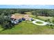 Aerial view of the home with solar panels, circular driveway and white fencing at 5750 Saddle Oak Trl, Sarasota, FL 34241