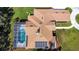 A bird's eye view showing the brown roof, screened-in pool, and circular driveway at 5750 Saddle Oak Trl, Sarasota, FL 34241