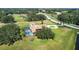 An aerial showcases the home's screened pool, circular drive, surrounding trees and grassy yard at 5750 Saddle Oak Trl, Sarasota, FL 34241