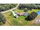 A drone view features the circular driveway, manicured lawn, pool, and white fence at 5750 Saddle Oak Trl, Sarasota, FL 34241