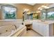 This bathroom features a tub, white cabinets, -and- vanities, and tile flooring at 5750 Saddle Oak Trl, Sarasota, FL 34241