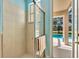 Bathroom featuring tiled shower and views of the outdoor pool and patio area at 5750 Saddle Oak Trl, Sarasota, FL 34241