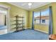 Bright bedroom featuring a ceiling fan, blue carpet, and a window providing ample natural light at 5750 Saddle Oak Trl, Sarasota, FL 34241