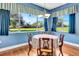 Bright dining room featuring a round table, hardwood floors, and serene views of the outdoor landscape at 5750 Saddle Oak Trl, Sarasota, FL 34241