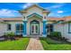 Inviting home entrance with blue accents, detailed trim, and brick walkway at 5750 Saddle Oak Trl, Sarasota, FL 34241