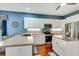Bright kitchen with stainless steel appliances, white cabinetry, and a center island for enhanced prep space at 5750 Saddle Oak Trl, Sarasota, FL 34241