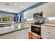 Modern kitchen with stainless steel appliances, white cabinetry, and breakfast area with backyard views at 5750 Saddle Oak Trl, Sarasota, FL 34241