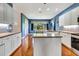 Spacious kitchen with white cabinets, countertops, and a large island, complemented by hardwood floors at 5750 Saddle Oak Trl, Sarasota, FL 34241
