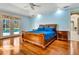 Spacious bedroom with wood floors, pool access via double doors, and stylish furnishings at 5750 Saddle Oak Trl, Sarasota, FL 34241