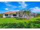 A view of the screened-in pool enclosure and lush backyard, with palm trees at 5750 Saddle Oak Trl, Sarasota, FL 34241