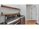 Well-equipped laundry room featuring modern washer, dryer, and wood shelving at 6832 Bay Hill Dr, Lakewood Ranch, FL 34202