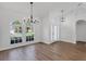 Bright living room with large windows, hardwood floors, and modern chandeliers at 6832 Bay Hill Dr, Lakewood Ranch, FL 34202