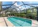 Sparkling screened-in pool surrounded by lush landscaping and lounge seating at 6832 Bay Hill Dr, Lakewood Ranch, FL 34202
