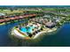 Aerial view of a pool and community center surrounded by lush greenery and shimmering lake waters at 701 Maraviya Blvd, Nokomis, FL 34275