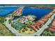 High angle view of a lakeside community clubhouse, tennis courts, and surrounding residences at 701 Maraviya Blvd, Nokomis, FL 34275