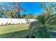 Well-maintained backyard with lush green grass, mature landscaping, and a white privacy fence at 701 Maraviya Blvd, Nokomis, FL 34275