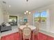 Sunlit dining area with views of the landscaped yard, modern furniture, and an open connection to the living space at 701 Maraviya Blvd, Nokomis, FL 34275