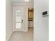 Bright entryway featuring a glass paneled door, light wood-look tile floors, and a glimpse into the laundry room at 701 Maraviya Blvd, Nokomis, FL 34275