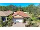 Charming single Gathering home with a tile roof, brick driveway and mature tropical landscaping at 701 Maraviya Blvd, Nokomis, FL 34275