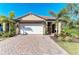 Beautiful single-story home with a brick driveway, tile roof, and lush, tropical landscaping at 701 Maraviya Blvd, Nokomis, FL 34275