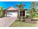 Inviting home featuring a brick driveway, tile roof, and well-maintained landscaping at 701 Maraviya Blvd, Nokomis, FL 34275