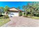 Charming home with a brick driveway, tile roof, and professionally landscaped yard at 701 Maraviya Blvd, Nokomis, FL 34275