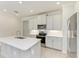 Modern kitchen featuring stainless steel appliances, white cabinets, and quartz countertops for a sleek and stylish look at 701 Maraviya Blvd, Nokomis, FL 34275
