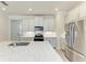Modern kitchen featuring stainless steel appliances, white cabinets, and quartz countertops for a sleek and stylish look at 701 Maraviya Blvd, Nokomis, FL 34275