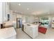 Open-concept kitchen with stainless steel appliances, white cabinets, and a spacious island overlooking the living area at 701 Maraviya Blvd, Nokomis, FL 34275