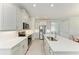 Bright kitchen with stainless steel appliances, a large island with quartz countertops, and ample storage space at 701 Maraviya Blvd, Nokomis, FL 34275