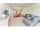 Open-concept living space with kitchen and dining area, featuring a gray sectional and view to the kitchen at 701 Maraviya Blvd, Nokomis, FL 34275