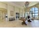 Elegant lobby with travertine flooring, stone accent walls, and floor-to-ceiling windows showcasing a picturesque lake view at 701 Maraviya Blvd, Nokomis, FL 34275
