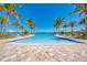 Inviting community pool with crystal-clear water, palm trees, and comfortable lounge seating for relaxation at 701 Maraviya Blvd, Nokomis, FL 34275