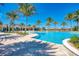 Resort-style community pool and clubhouse surrounded by tropical palm trees with ample lounge space for relaxation at 701 Maraviya Blvd, Nokomis, FL 34275